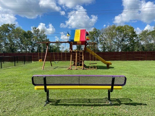 Kids playground with swings and slide at Angleton RV Park & Resort